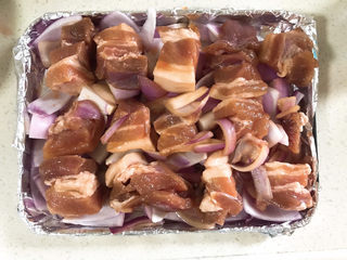 5、烤箱版叉烧,第二天取出，烤盘铺上一层锡纸，放上洋葱，最后放五花肉