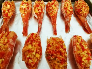 11、一虾三吃～阿根廷大红虾的花样吃法,烤盘垫上锡纸，把大蒜红辣椒碎填入虾背里面，依次做好放进烤盘，同时预热烤箱，220度上下火十分钟左右