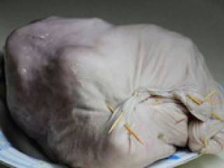 3、凤凰投胎(猪肚包鸡),将鸡放进洗净的猪肚内,然后再往猪肚里塞一半红枣和一半炒香的白胡椒粒。