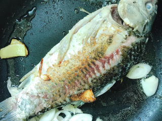 7、奶白鲫鱼豆腐汤,煎至两面金黄。