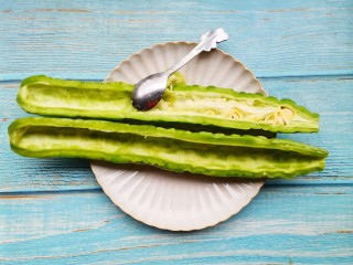 3、凉拌苦瓜,用勺子将里面的白色部分全部挖掉，