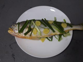 8、清蒸黄鱼,在黄花鱼表面上铺上姜片和葱段
