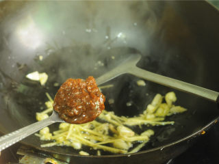 3、芹菜炒晒兰肉,转小火，加入一勺豆瓣酱