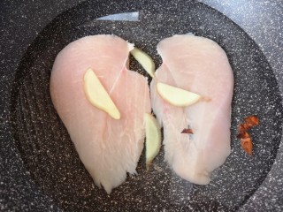 3、手撕鸡胸肉,凉水入锅，加入生姜片、料酒、八角和少许盐。
