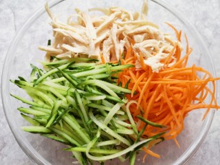 9、手撕鸡胸肉,将撕好的鸡胸肉和胡萝卜黄瓜丝一起放进盆里。