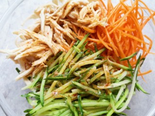 12、手撕鸡胸肉,将调好的酱汁浇在鸡胸肉和菜丝上面。