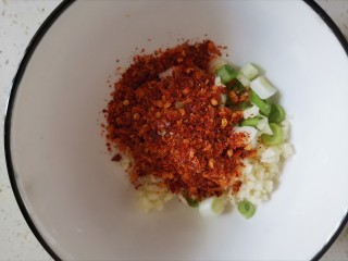 7、香辣藕片,大蒜和葱白加入碗中，加入两勺辣椒面