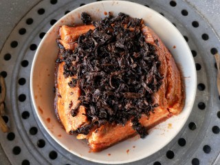 13、梅菜扣肉,将浸泡好的梅菜挤干水分,铺放到肉的上面;再倒入腌肉的原汤,上锅隔水蒸2-2.5小时(视个人口味而定,喜欢肉绵点的就时间长点)。