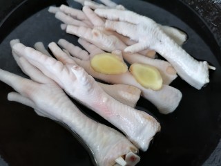 3、无骨鸡爪,将鸡爪放入锅内焯水放两片生姜去腥