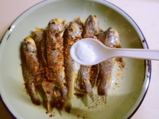 6、香辣小黄鱼,放入盐。