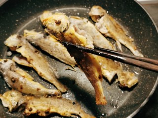 12、香辣小黄鱼,待一面定型后，翻另一面煎制。