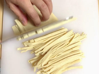 6、凉拌千张,将豆腐皮切成丝。