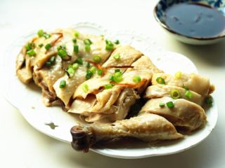 12、葱油白斩鸡,鸡身上撒上小葱碎，蘸着料汁食用。