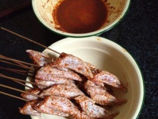 4、烤鸡翅尖,用竹签2个一串的把串好，腌制的汁留着待用