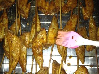 6、烤鸡翅尖,拿出来刷上腌汁再烤10分钟，烤好装盘，撒上芝麻即可