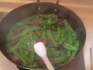 8、香肠炒荷兰豆,放入一勺半盐＋一勺糖。蒙盖一分钟。起锅。