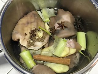 10、家乡食谱～猪头肉,把上面的香料倒入锅里，加入冰糖，葱段和姜片，还有蒜瓣儿。