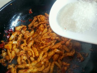 15、绿色美食＋蒜苔炒肉丝,倒入3克白糖，翻炒均匀。白糖，可提味增香。