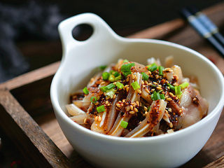 6、凉拌猪耳朵,放入碗中，将调料汁浇在耳片上，再撒点葱花点缀