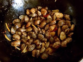 7、辣炒蛤蜊,倒入蛤蜊继续翻炒。