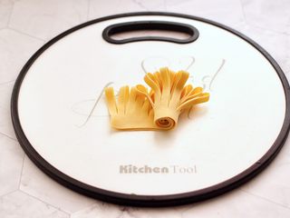 6、凉拌菊花豆皮,然后从豆皮的一端开始卷起。