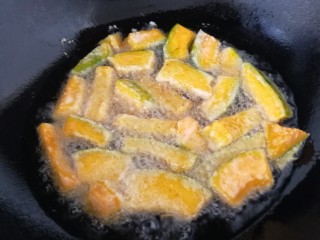 11、蛋黄焗南瓜,油温6-7成热时，中火，一个一个的把南瓜条放入油里。炸3分钟。