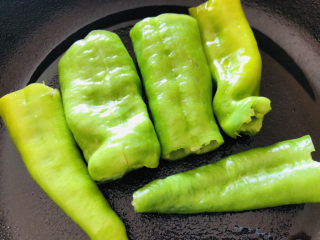 5、尖椒皮蛋,平底不粘锅中加一点点食用油，放入尖椒煎制表面上色。