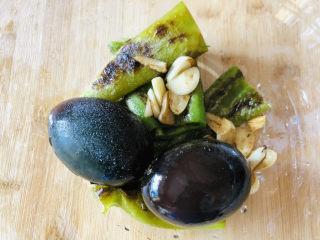 10、尖椒皮蛋,碗里放入皮蛋、煎好的蒜瓣和尖椒。