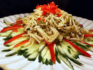 15、黄瓜凉拌金针菇,黄瓜丝码盘，上面放红彩椒丝，最后加上酸豆角金针菇就完成了