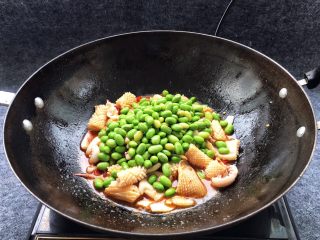 16、酱爆鱿鱼花,继续大火翻炒片刻,倒入煮好的毛豆一起翻炒。