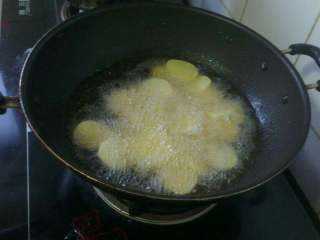 4、自制麻辣香锅,炒锅放油烧热，下入土豆片炸1分钟；