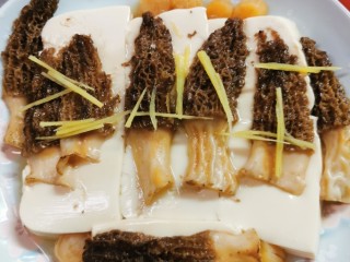 7、羊肚菌蒸豆腐,用筷子按着豆腐，把汤汁倒进锅内。（带个隔热手套，注意别烫着手）