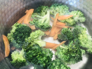 4、蒜蓉西兰花,锅中加入适量清水烧开，水开后放入泡好的西兰花、胡萝卜焯水。