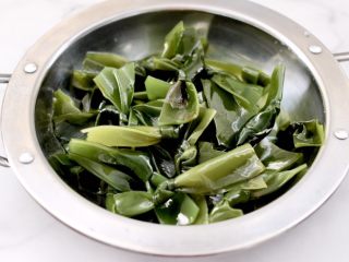11、蒜香海带结花生米,把焯好的海带结放入容器中。