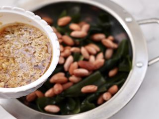 13、蒜香海带结花生米,上面倒入调制好的调料汁。