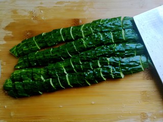 4、捞汁凉菜,黄瓜用刀拍碎，切成小块。