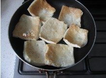 2、孜然千页豆腐,平底锅热油放入豆腐片煎至两面金黄，放入碗里凉后很快回缩