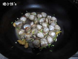 5、酒蒸蛤蜊,加一小块黄油~撒入一把葱花~大火烹翻炒几下即可出锅