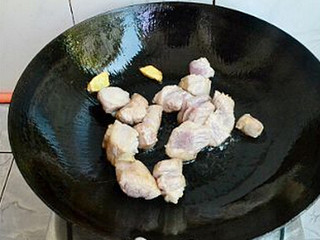 3、干豆角香焖五花肉,锅内放入一点点的油，烧热，加入姜片爆香，再放入五花肉爆至微金黄