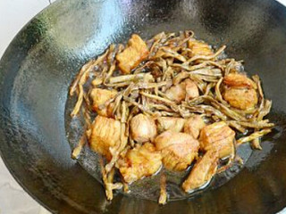 4、干豆角香焖五花肉,调入适量的生抽、老抽、冰糖、料酒，再加入豆角干翻炒均匀，再加入四汤勺料酒和没过肉块的水