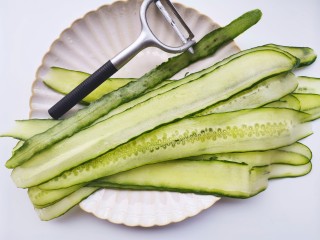 2、响油黄瓜卷,黄瓜洗净去头尾，用削皮刀从一头开始往下削成长片状，