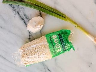 1、凉拌金针菇,准备好金针菇，蒜，葱，我自己是比较爱吃蒜的，所以准备了一大球。