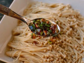 8、凉拌金针菇,酱汁煮沸就关火。不要烧得太熟，这样才能保持新鲜的味道!慢慢地把酱汁倒在金针菇菇上。