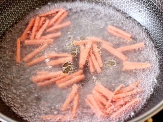 12、超过瘾好吃的酸辣银丝,锅中倒入适量清水煮沸，放入火腿丝焯软捞出沥干水分。