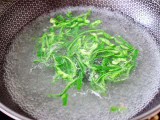 13、超过瘾好吃的酸辣银丝,把青椒丝放入锅中焯30秒立马捞出沥干水分。