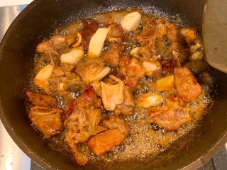 6、茶香排骨,加入蒜粒姜片炒香,放入酱油翻炒