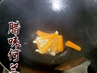 2、腊味荷兰豆,起油锅，下蒜蓉和胡萝卜，因为胡萝卜的熟成比荷兰豆慢，所以要先炒。