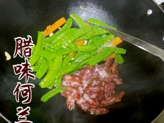 4、腊味荷兰豆,将荷兰豆推到一边，加入腊肠，待腊肠炒出油后将食材拌匀。