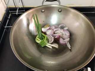 11、酸辣黄瓜条,加入小葱，洋葱，中小火煸到小葱洋葱焦黄