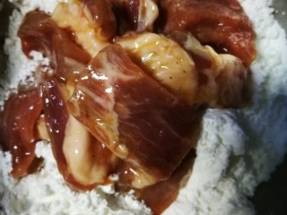 10、咕咾肉,桨好的肉块裹上生粉。
